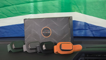 The Car Edit gift box on a car dashboard with the Visor Clip in green, grey, black and tan