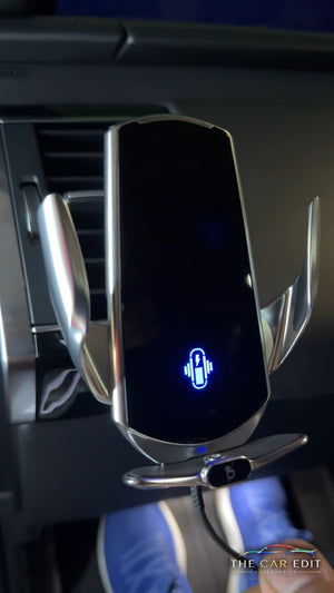 GripBot auto-clamp wireless charging mount fitted to a car air vent, charging icon lit